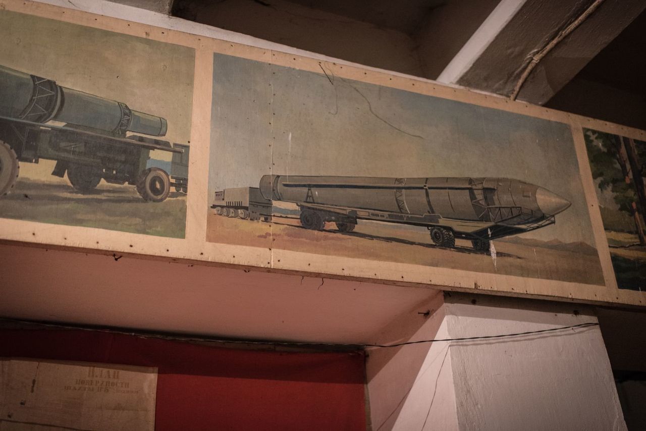 Soviet-era paintings and slogans adorn the walls above makeshift beds and shelves that people have set up over the last two years.