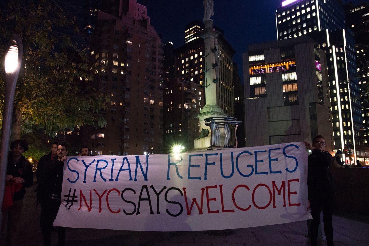 Demonstrators hold up signs of support for refugees at a rally last year against Donald Trump's proposed ban on asylum for Muslim immigrants.