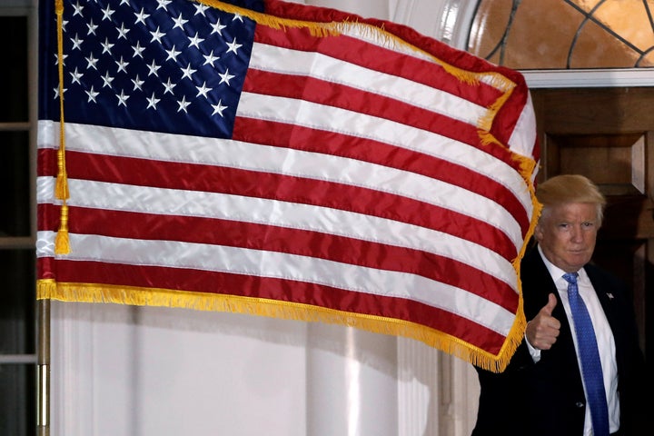 U.S. President-elect Donald Trump gestures to the news media as he appears outside the main clubhouse at Trump National Golf