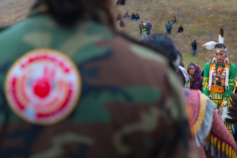 A TIME TO REFLECT. A Jingle dancer and water protectors at the sacred ceremonial Jingle dance on October 29 at the Treaty/Sac
