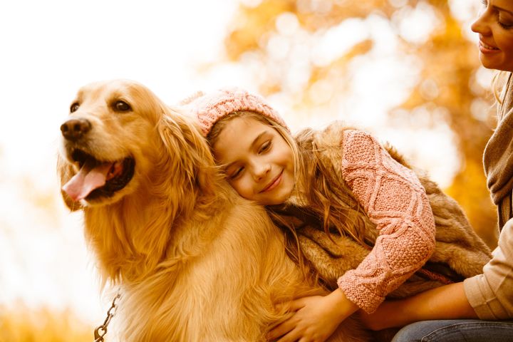 Mother and daughter with their dog in autumn park fotostorm via Getty Images