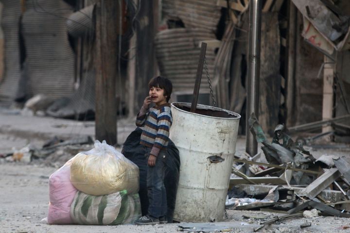 A boy stands in the damage of Aleppo's besieged al-Shaar neighborhood.