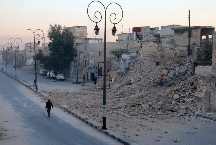 A man walks past a damaged site in Aleppo's Qadi Askar neighborhood.