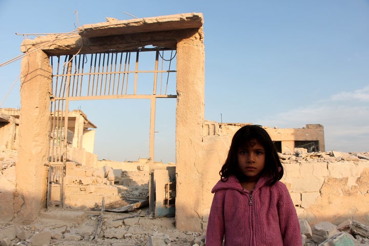 A Syrian girl is seen in front of the school in Haas that was destroyed by an Oct. 26 airstrike.