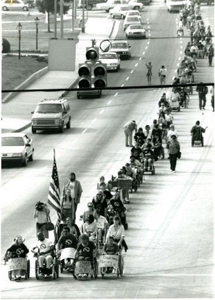 Photo: ADAPT disability rights activists marching in the streets in protest in 1990. 