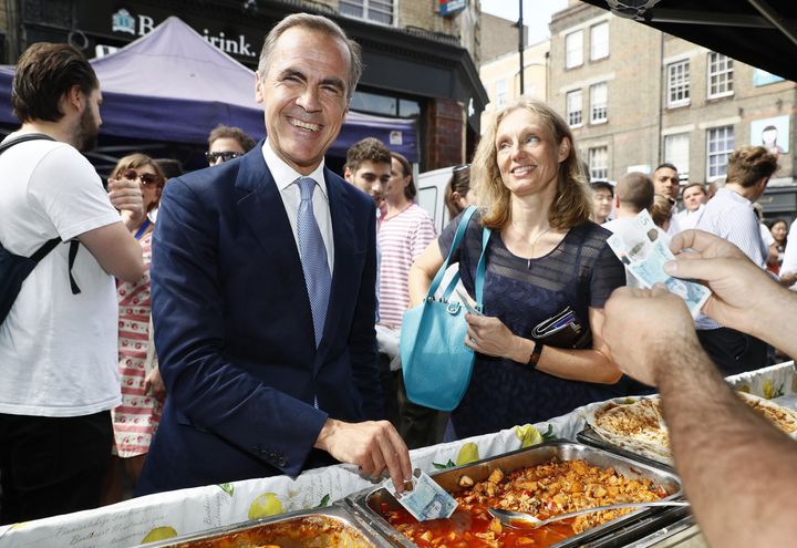 Bank of England Governor Mark Carney demonstrates the new £5 note's durability