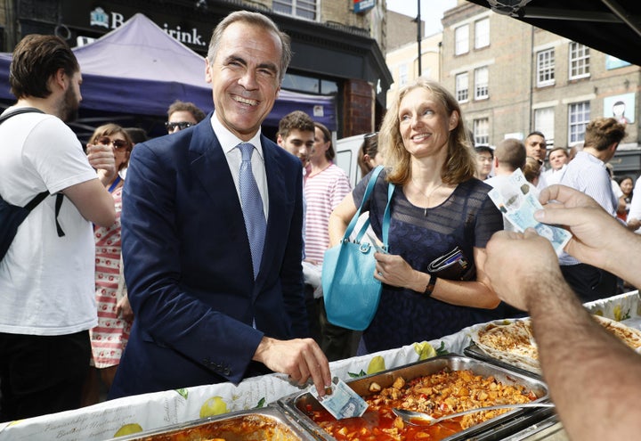 Bank of England Governor Mark Carney demonstrates the new fiver's durability