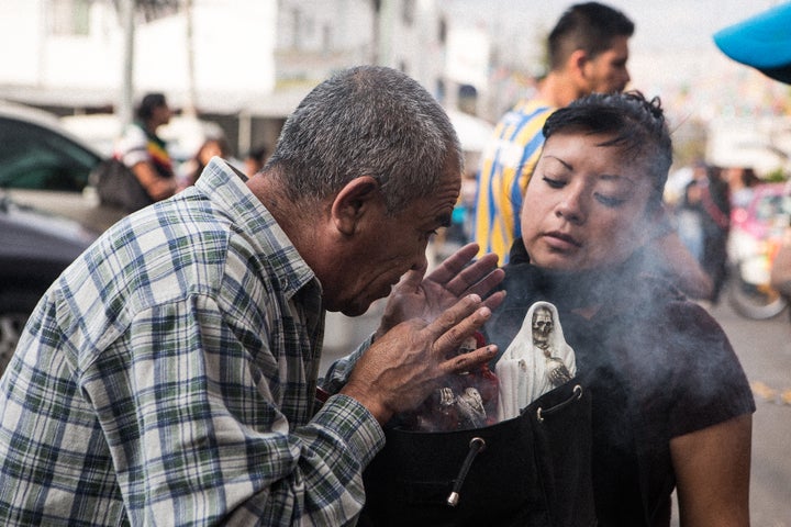 <p>Blessing Santa Muerte with holy smoke at the Tepito shrine</p>