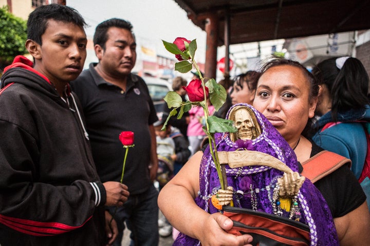 A devotee at the Tepito shrine with her purple Santa Muerte for healing