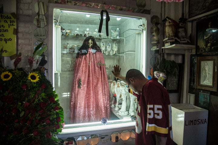 <p>A devotee praying at the Santa Muerte shrine in Tepito</p>