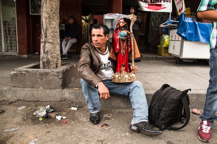 A devotee at the Santa Muerte shrine in Tepito with his Lady in Red for love and passion