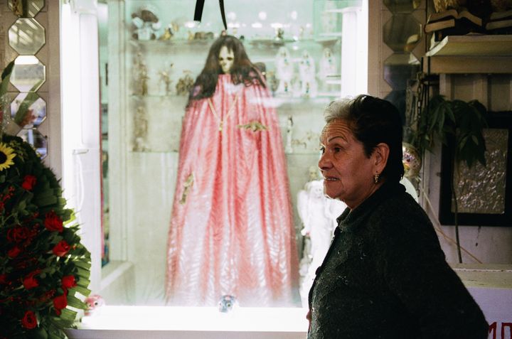 <p>Santa Muerte Godmother Enriqueta Romero with the most famous effigy of the Bony Lady at her Tepito shrine</p>