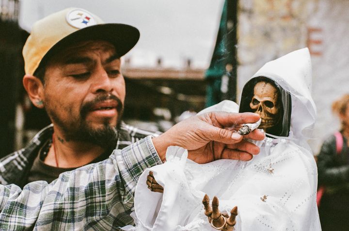 A devotee offering a marihuana joint to the Bony Lady at the Santa Muerte shrine in Tepito