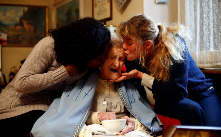 Emma Morano receives kisses from her caregivers, Malgorzat Ceglinska and Yamilec Vergara, during her 117th birthday party.