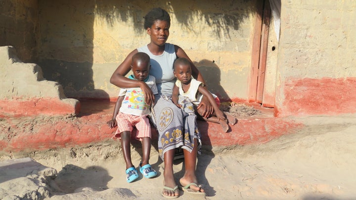 <p>Mother with her children in front of her home in Zambia</p>