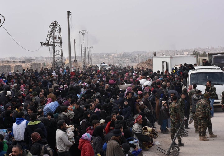 Syrians that evacuated the eastern districts of Aleppo gather to board buses, in a government held area in Aleppo, Syria in this handout picture provided by SANA on November 29, 2016.