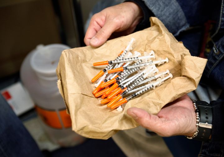 A woman shows her clean syringes at the Aids Center of Queens County needle exchange outreach center in New York, 2006.