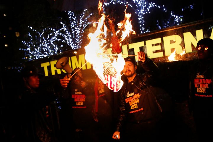 Supporters of the NYC Revolution Club burn the U.S. flag outside the Trump International Hotel and Tower in New York, U.S.