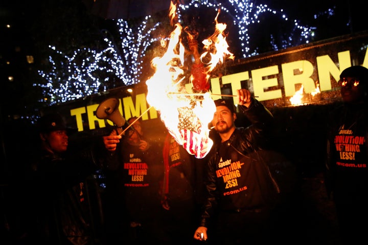 Supporters of the NYC Revolution Club burn the U.S. flag outside the Trump International Hotel and Tower in New York, U.S.