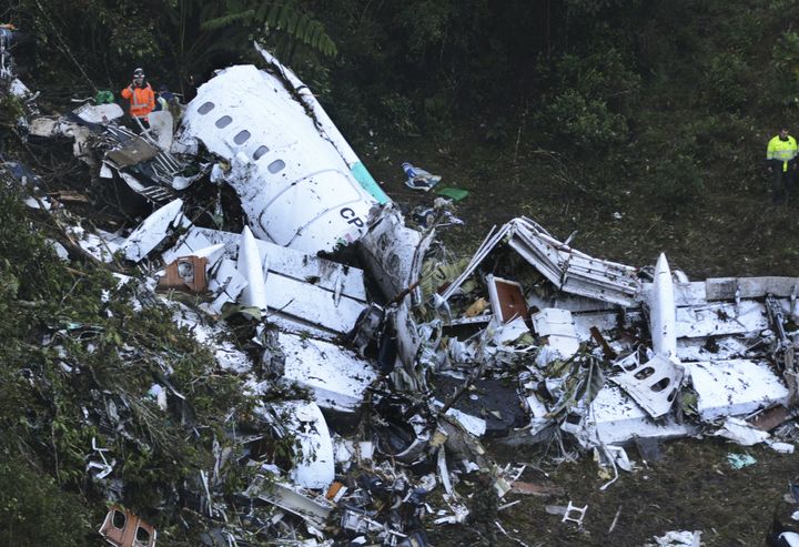 Rescue workers stand at the wreckage site of a chartered airplane that crashed in a mountainous area outside Medellin, Colombia.