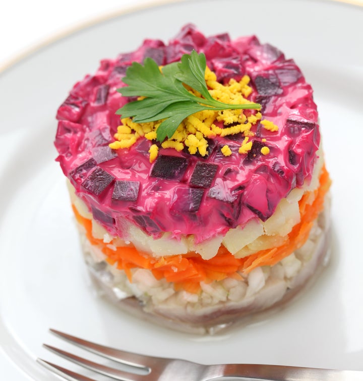 Fur-coat herring, a traditional dish layered with salted herring, cooked vegetables, and a coat of grated beets and mayo.