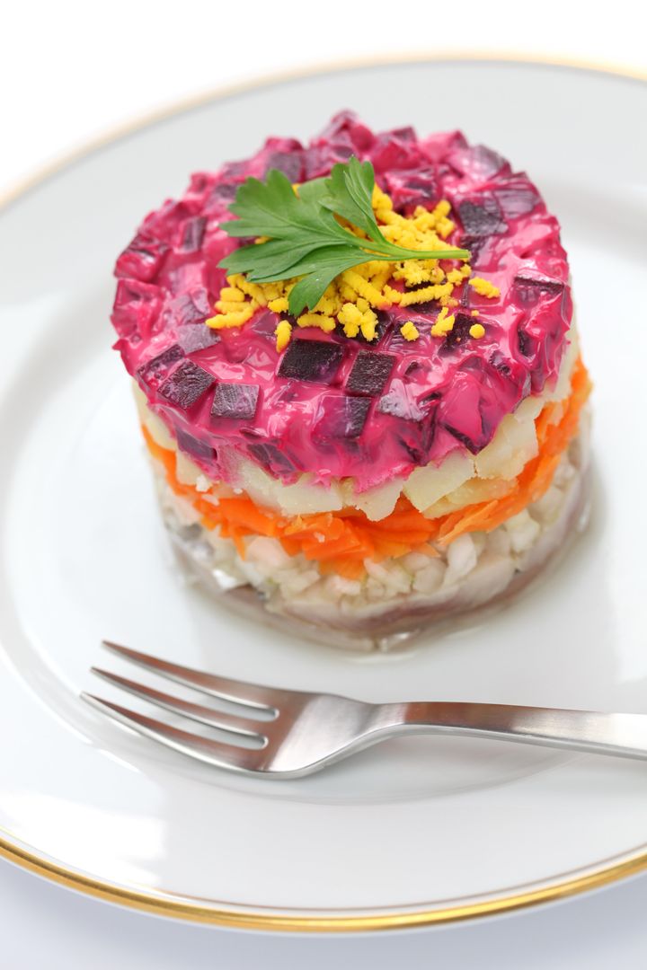 Fur-coat herring, a traditional dish layered with salted herring, cooked vegetables, and a coat of grated beets and mayo.