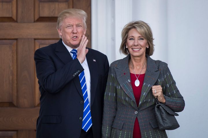 President-elect Donald Trump stands with Betsy DeVos after a meeting in Bedminster Township, New Jersey, on Nov. 19.