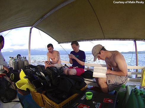 Rutgers University researchers Patrick Flanagan, Michelle Stuart, and Malin Pinsky (left to right) check equipment and prepare for a dive to study reef fish off the island of Leyte in the central Philippines in 2015. This research helps the team understand how fish populations go extinct and how they colonize new territory—key processes driving fish to cooler waters in North America and around the world.