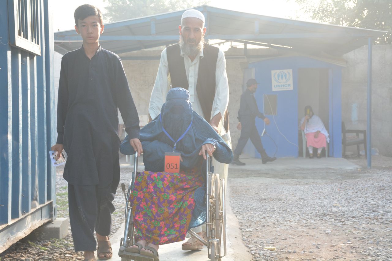 Roz Qul, 55, and his family walk through the UNHCR repatriation camp in Peshawar, Pakistan. Qul and his family are headed back to Afghanistan under pressure from the Pakistani government.