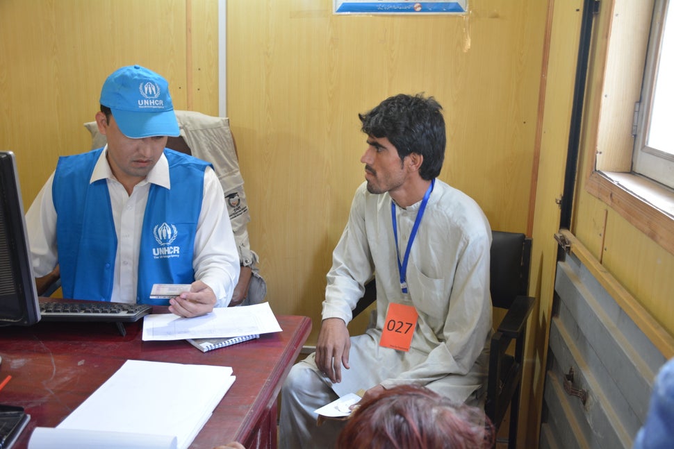 A UNHCR official checks the identification card of Musa Khan, 32, as he goes through the process of repatriation to Afghanist