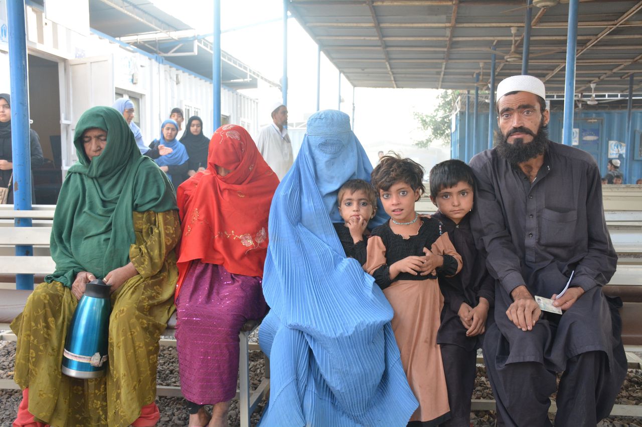 A family sits on a bench at the UNHCR repatriation center in Peshawar, Pakistan while they wait for their forms to be approved to cross the border into Afghanistan.
