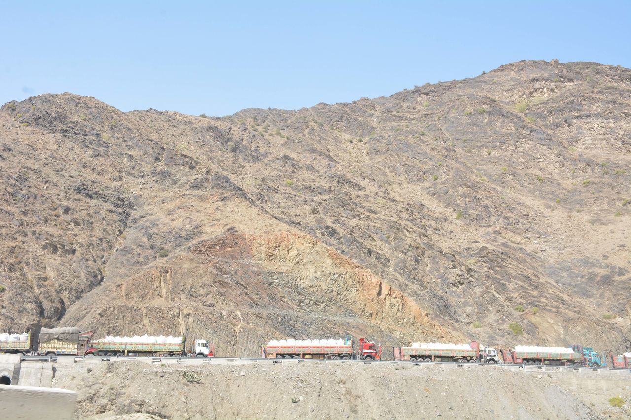 Large trucks carry the belongings of Afghan refugees as they make their way towards the Torkham border to resettle in their native Afghanistan.