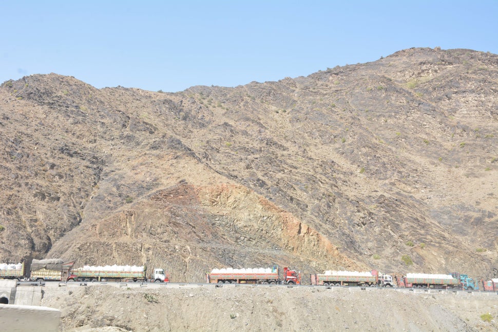 Large trucks carry the belongings of Afghan refugees as they make their way towards the Torkham border to resettle in their n