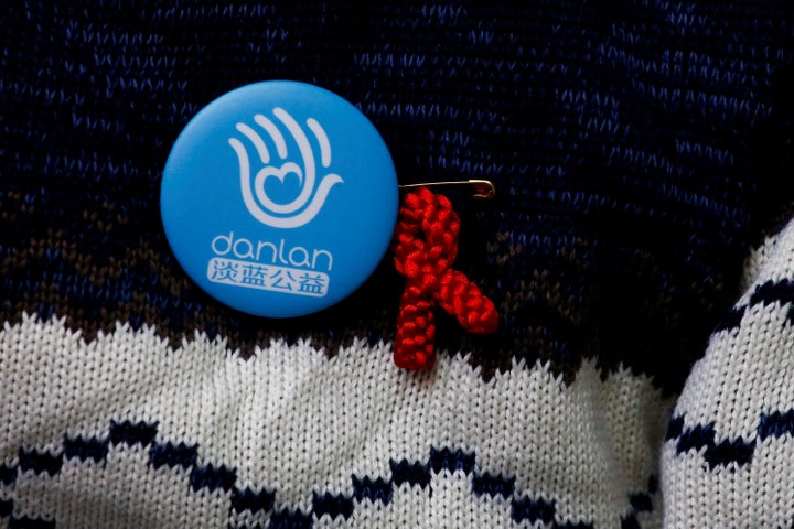 A volunteer wears a red ribbon at an office of Danlan, an organization running HIV tests and prevention programs, in Beijing.