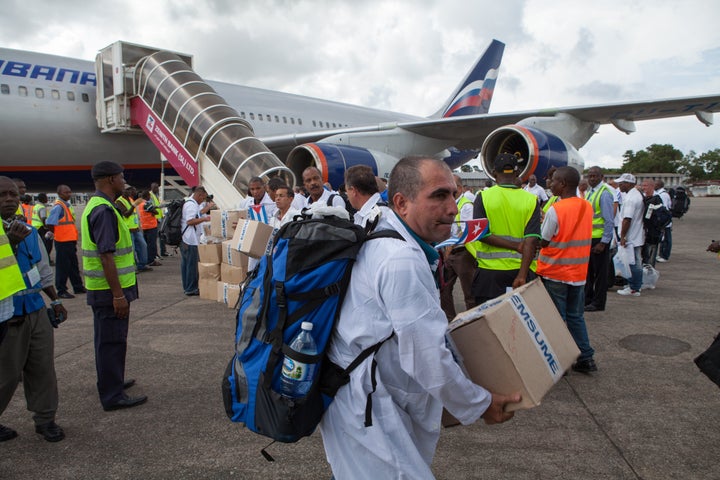 The first members of a team of 165 Cuban doctors and health workers unload medical supplies at the airport in Freetown, Sierra Leone, as they arrive to help fight Ebola in 2014.