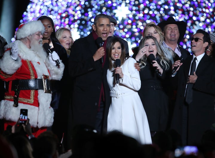 President Barack Obama sings "Jingle Bells" with, from left, daughter Sasha, Caroline Smedvig, James Taylor, Eva Longoria, Ke
