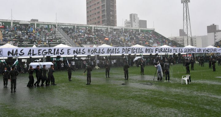 <strong>Soldiers carry a coffin into the stadium under heavy rain</strong>