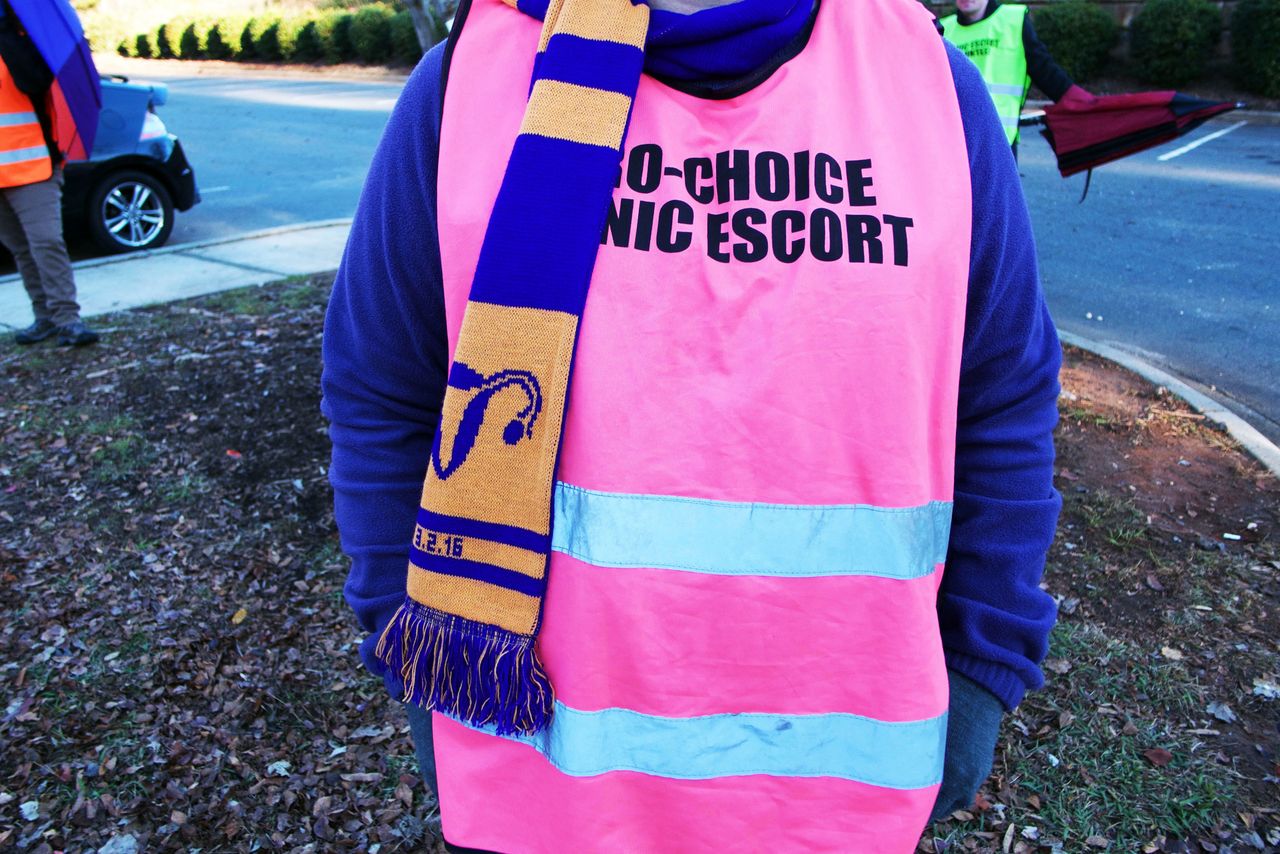 A volunteer clinic escort stands in the parking lot of A Preferred Women's Health Center on Saturday morning in Charlotte, North Carolina. 