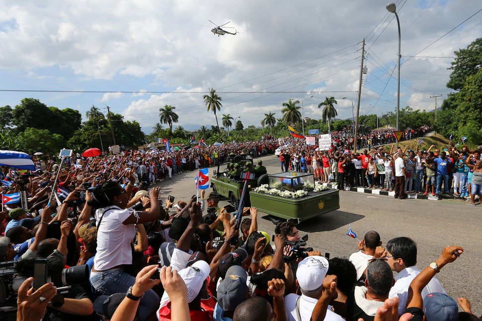 People line a street to watch as the caravan carrying the ashes of Cuba's late President Fidel Castro arrives in Santiago de