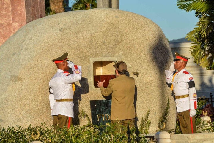 Cuba's President Raul Castro (C) places the box containing the ashes of Cuba's former President Fidel Castro into a boulder at the Santa Ifigenia Cemetery, in Santiago de Cuba, December 4, 2016.