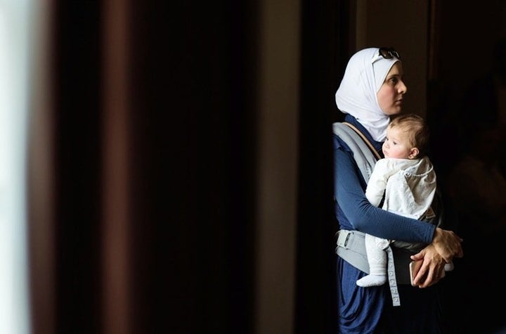 Hiba Tinawi, from Syria, holds her six-month-old daughter Judy during an event to welcome Syrian refugee families who have re