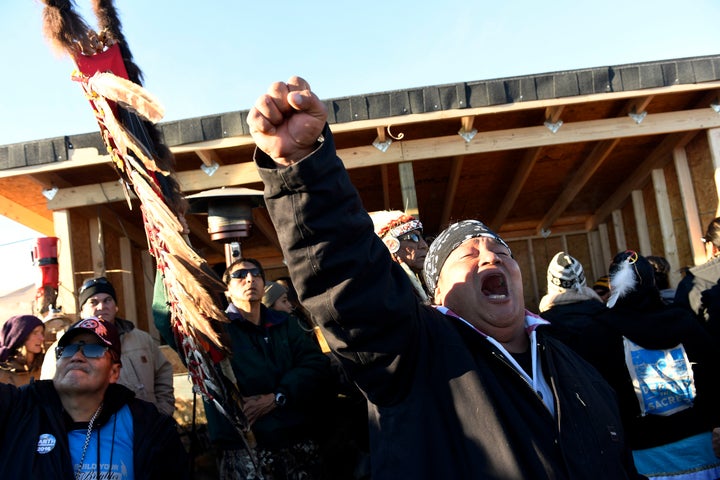 Troy Fairbanks, right, of the Standing Rock Sioux tribe cheers after hearing Chief Arvol Looking Horse announce to members of over 300 nations that the pipeline's construction has been halted.