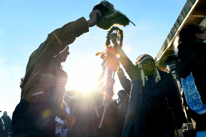 Native americans lift up their hands to celebrate their victory.