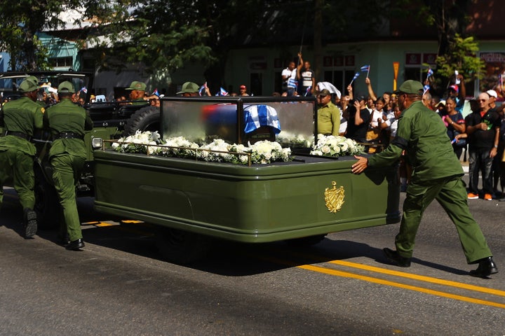 Soldiers push the vehicle and trailer carrying the ashes of Fidel Castro after it broke down during the procession. 