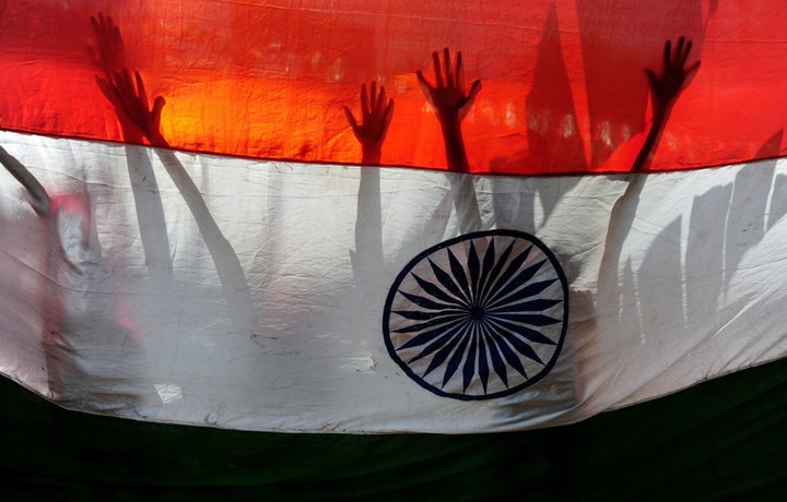 Indian schoolchildren stand behind a national flag during Independence Day celebrations in Chennai on Aug. 15.