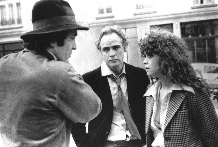 Bernardo Bertolucci, left, discusses a scene from "Last Tango in Paris" with Marlon Brando and Maria Schneider.