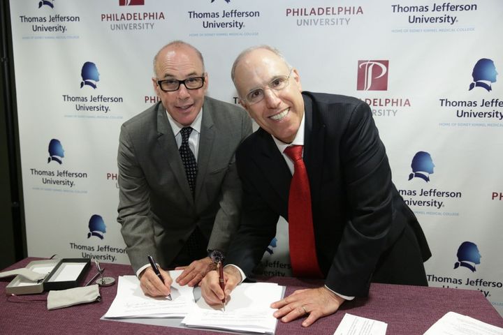Dr. Stephen Klasko, president & CEO of Thomas Jefferson University and Jefferson Health, and Philadelphia University president Dr. Stephen Spinelli sign the agreement to combine the two institutions into one comprehensive university in 2017. 