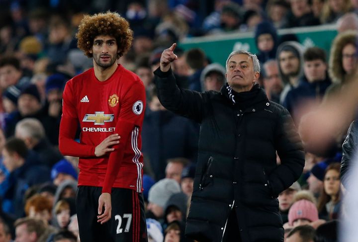 Manchester United's Marouane Fellaini prepares to come on as a substitute as manager Jose Mourinho looks on.