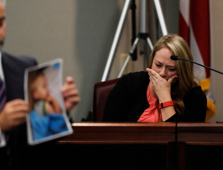 Leanna Taylor is seen crying on the stand as an attorney holds up photos of her son, Cooper, who died after being left inside