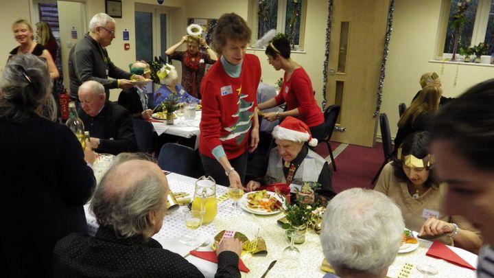 Caroline serving food at a Community Christmas meal.